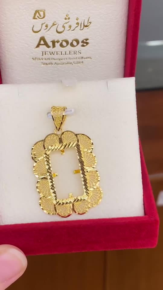 A 21 carat gold ounce frame pendant in the shop's own maroon box